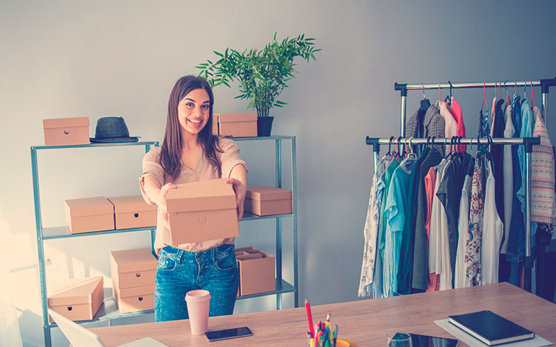 Una vendedora prepara paquetes de productos para su entrega al cliente. Venta en línea o comercio electrónico