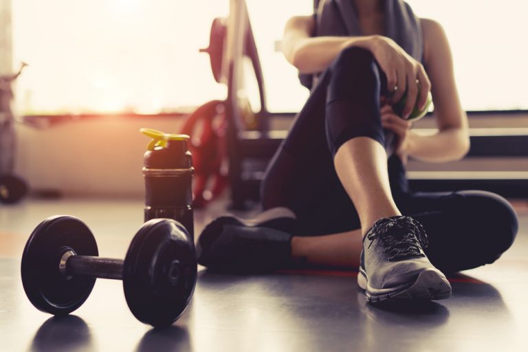 Una mujer junto con unas pesas en un gimnasio