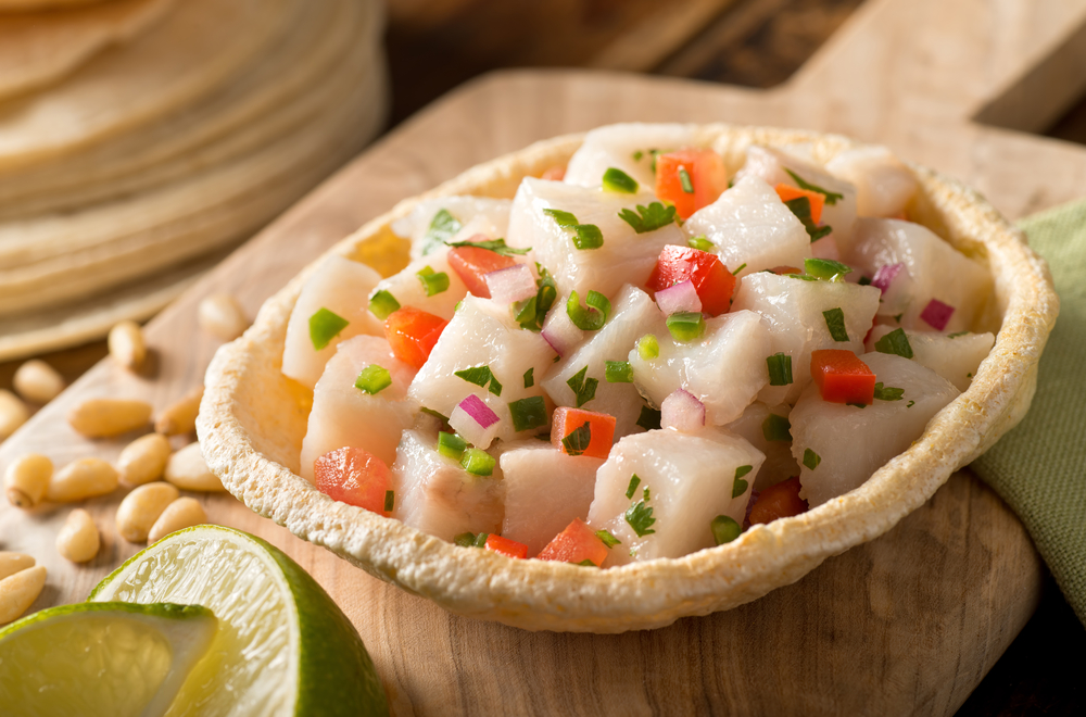 Un ceviche de pescado blanco recién hecho con tomate, cebolla roja, cilantro, pimienta roja, lima y pimienta serrano.