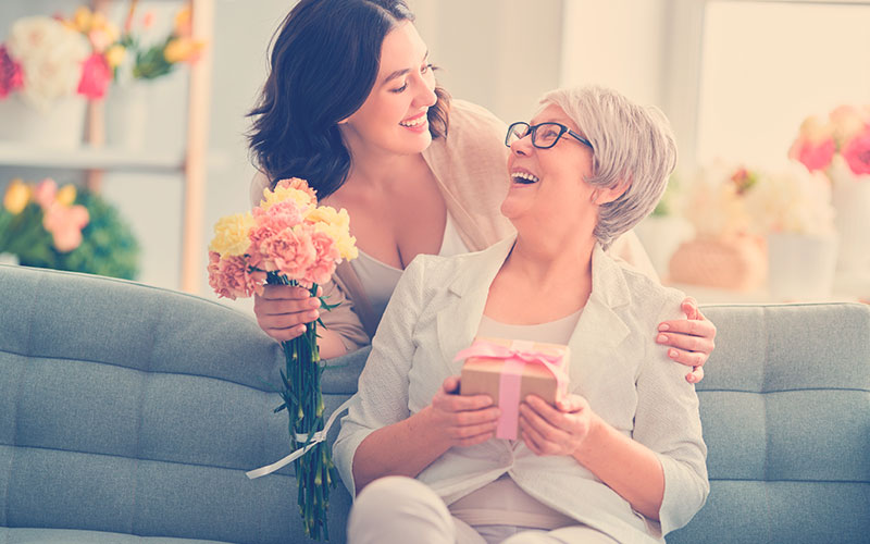 HIja regalándole flores a su mamá