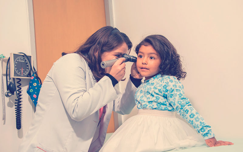 Médica revisando a una niña