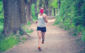 Mujer deportiva atlética trotando al aire libre en la naturaleza,