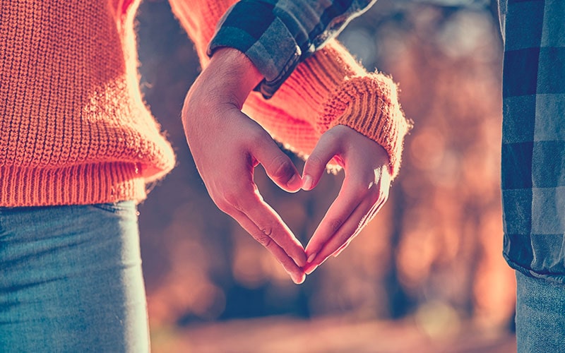 Manos de una pareja formando un corazón