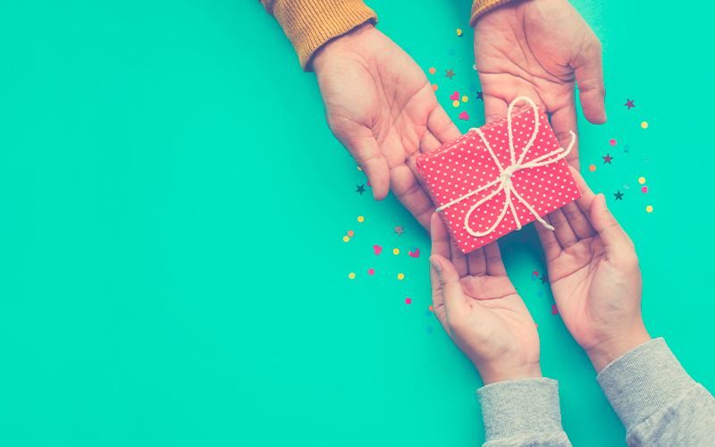 Manos de un padre y un hijo aprendiendo a dar y recibir regalos