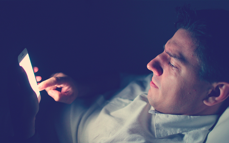 Hombre revisando su celular en horas de la noche