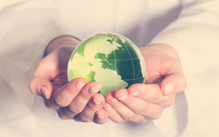 manos sosteniendo el planeta Tierra