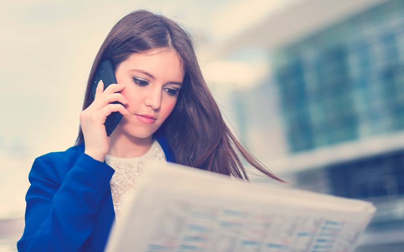 Mujer leyendo un periódico para encontrar trabajo