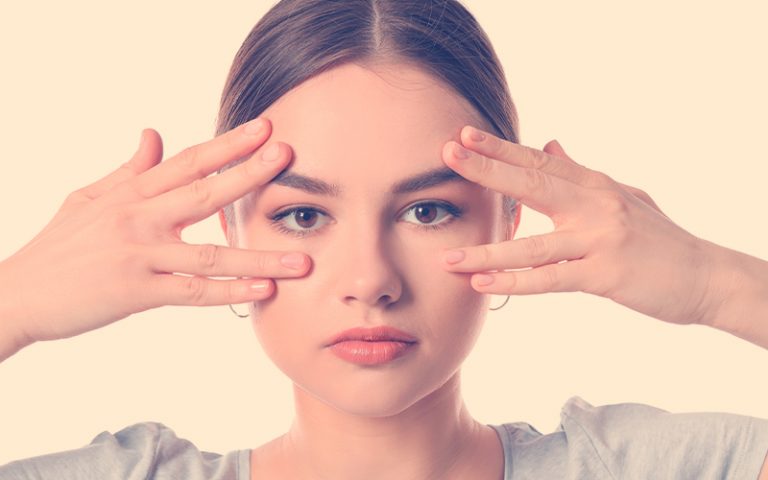 Hermosa joven haciendo yoga facial con fondo blanco