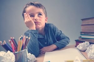 niño estudiando se siente aburrido y con estrés