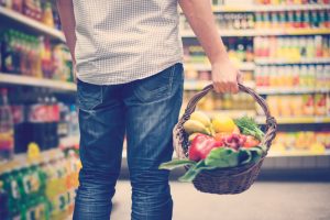 persona hace mercado incluyendo alimentos sanos para preparar comidas saludables con bajo presupuesto