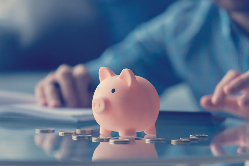 Monedas en euros de banco de cerdo rosado sobre la mesa