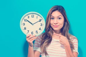 mujer en fondo azul señala reloj de rutina diaria