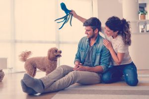 pareja juega con su nuevo perro en casa