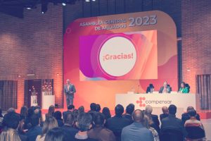 Personas reunidas en la asamblea general de afiliados viendo una diapositiva que dice: Gracias