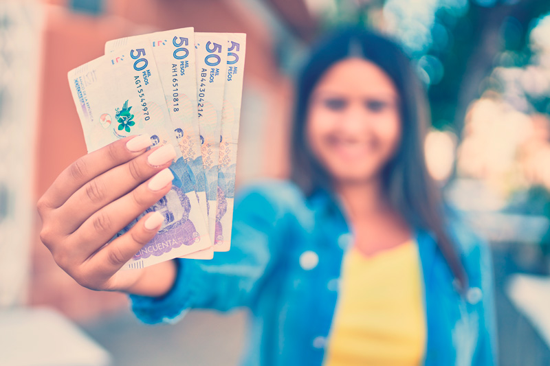 mujer colombiana muestra billetes de 50 mil