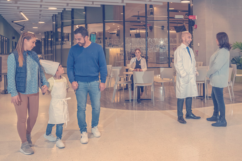 Una familia de tres integrantes y personal médico en un centro de bienestar integral.