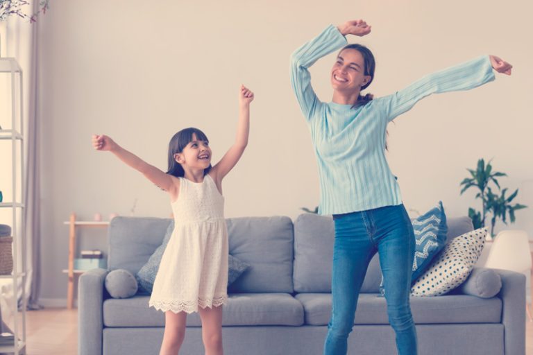 mamá e hija bailando en casa