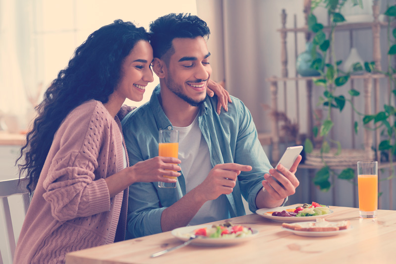 ersonas usando smartphone Mientras desayunan en cocina