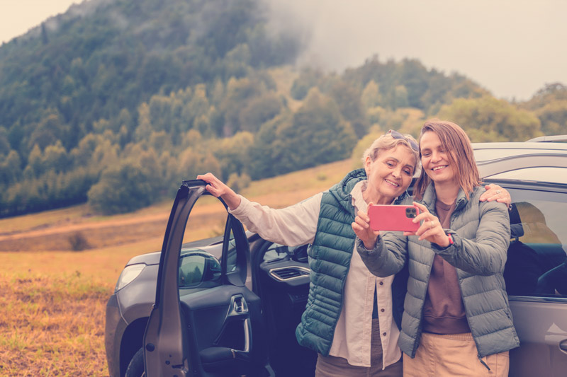 mujeres viajando tomándose una foto en un carr