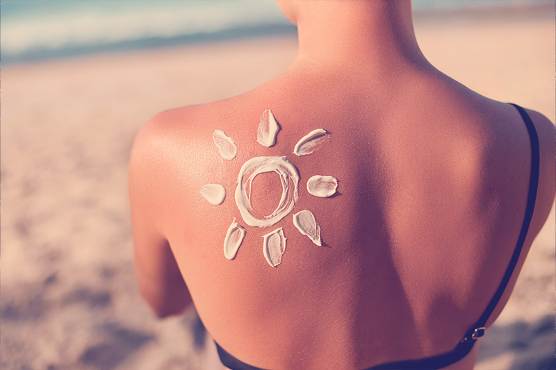 mujer en la playa se expone al sol