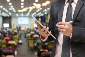 Hombre con Tablet participando en evento.