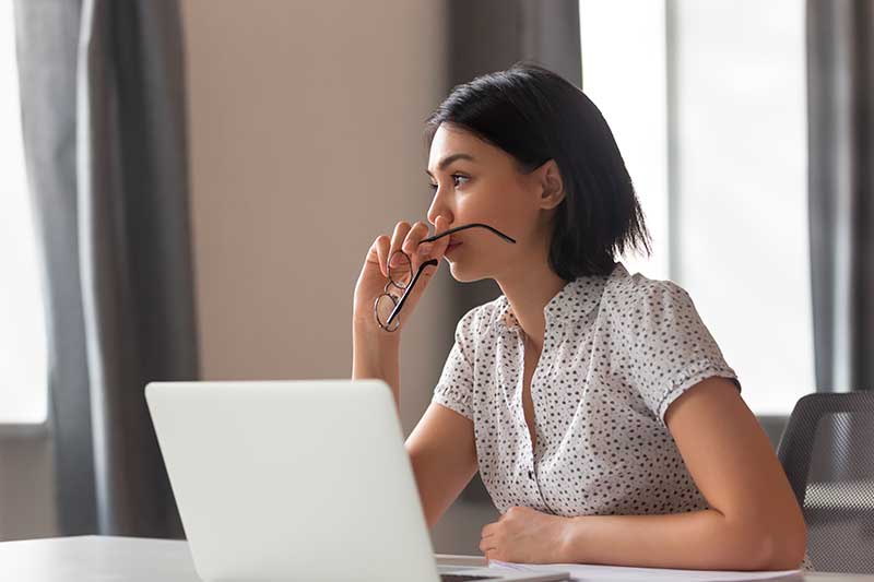 mujer pensativa frente al computador