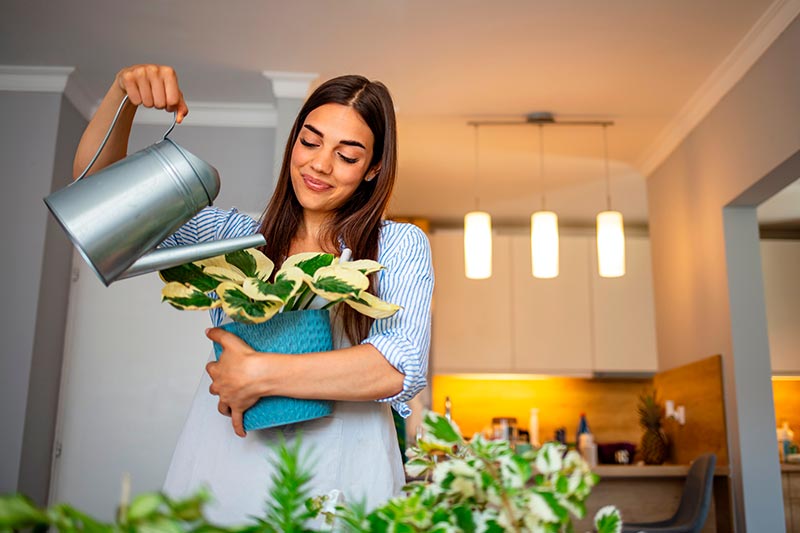 mujer feliz regando plantas