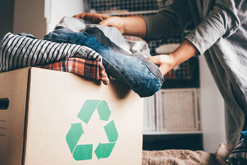 caja de reciclaje llena de ropa 