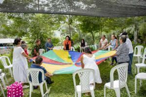 adultos de la tercera edad realizado actividad con una tela de colores y pelota