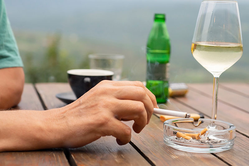 mano de un hombre sostiene un cigarrillo