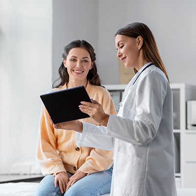 doctora con tableta y mujer en el hospital