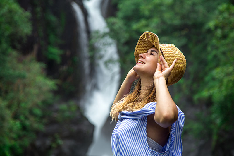 chica con sombrero disfruta el turismo de naturaleza