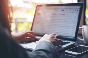 Persona escribiendo un correo electrónico profesional en una laptop siguiendo las claves para una comunicación clara y efectiva.