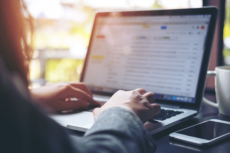 Persona escribiendo un correo electrónico profesional en una laptop siguiendo las claves para una comunicación clara y efectiva.