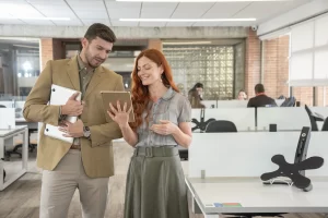 Profesionales revisando la liquidación de aportes a seguridad social en una tablet dentro de una oficina.