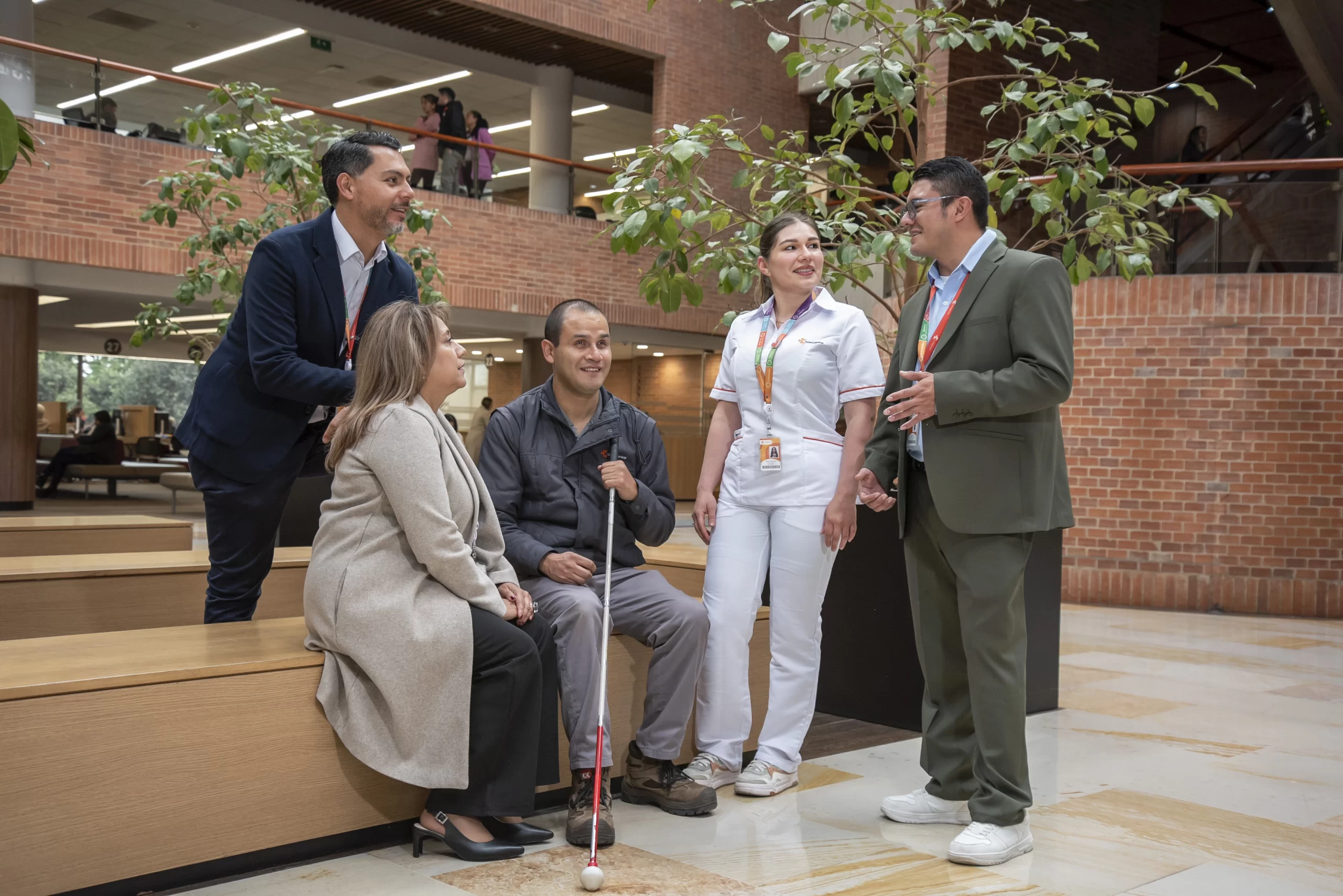 Grupo de colaboradores diversos en Compensar, incluyendo a una persona con discapacidad visual, participando en un proceso de formación en DEI para fortalecer la cultura laboral incluyente.