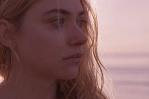 Mujer con expresión reflexiva cerca del mar procesando qué hacer en una crisis emocional