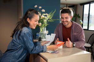 Pareja analizando sus finanzas con la app Billetera Móvil para solicitar un crédito social Compensar.