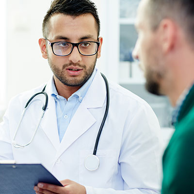 Médico especialista dialogando con un paciente sobre cómo cuidar la salud de la próstata y prevenir enfermedades.