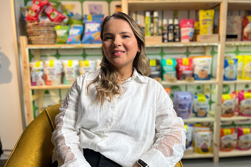 Francisca Meza, cofundadora de Biodistribuciones Terra, posando frente a estantería de productos sin gluten Karavansay.